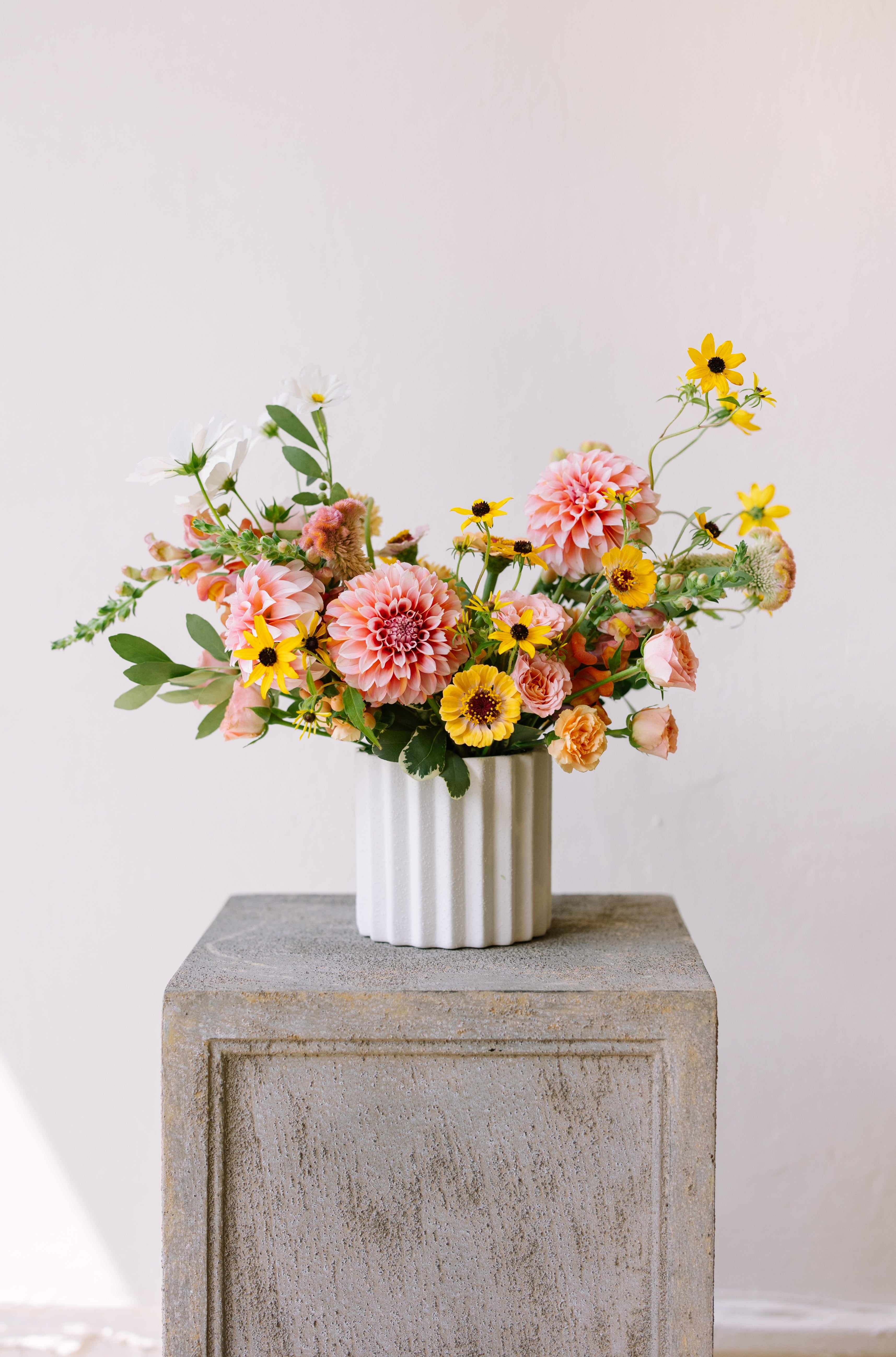 Garden flower arrangement in a textured white vase