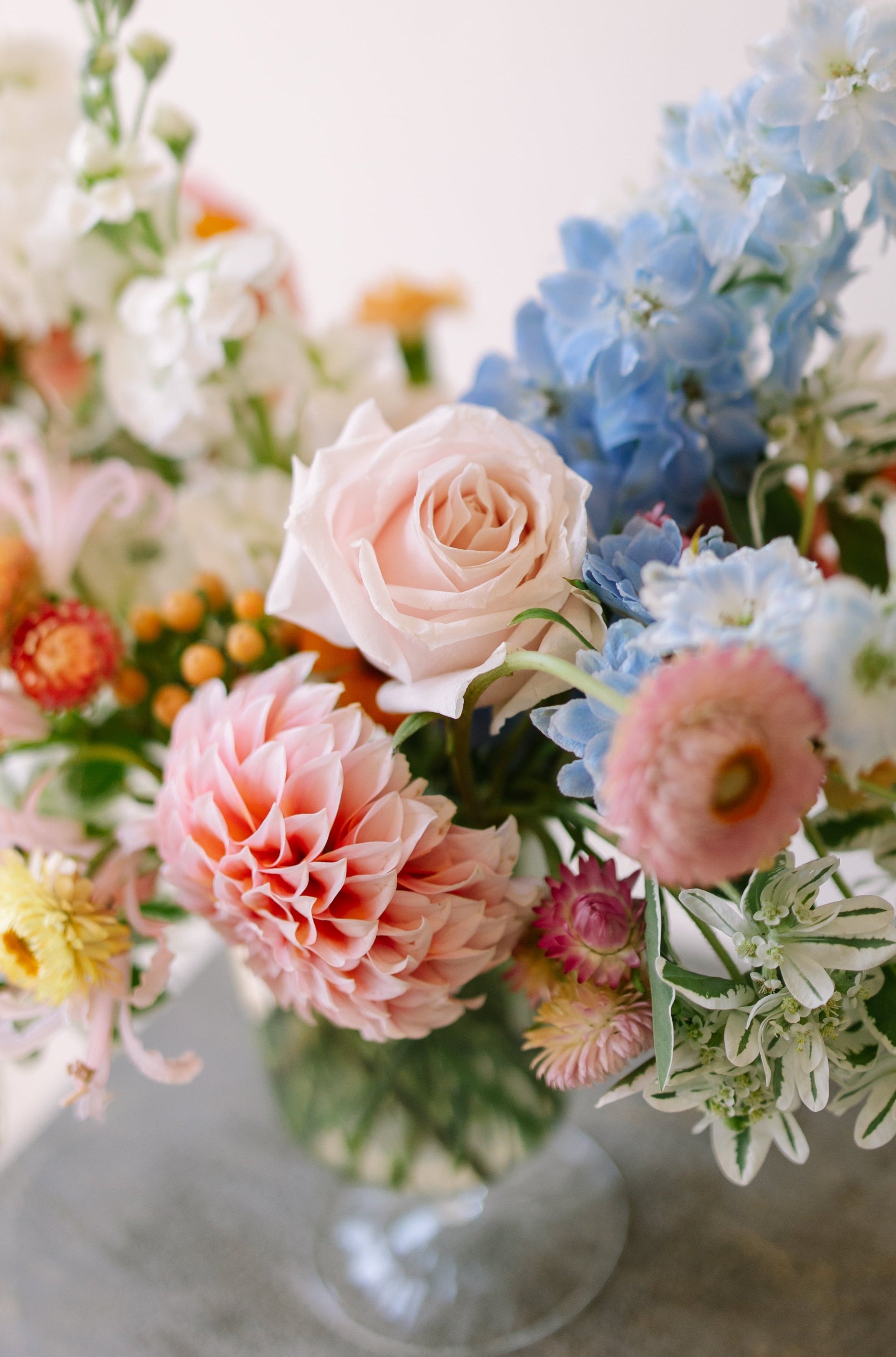 Garden flower arrangement in a footed glass vase.