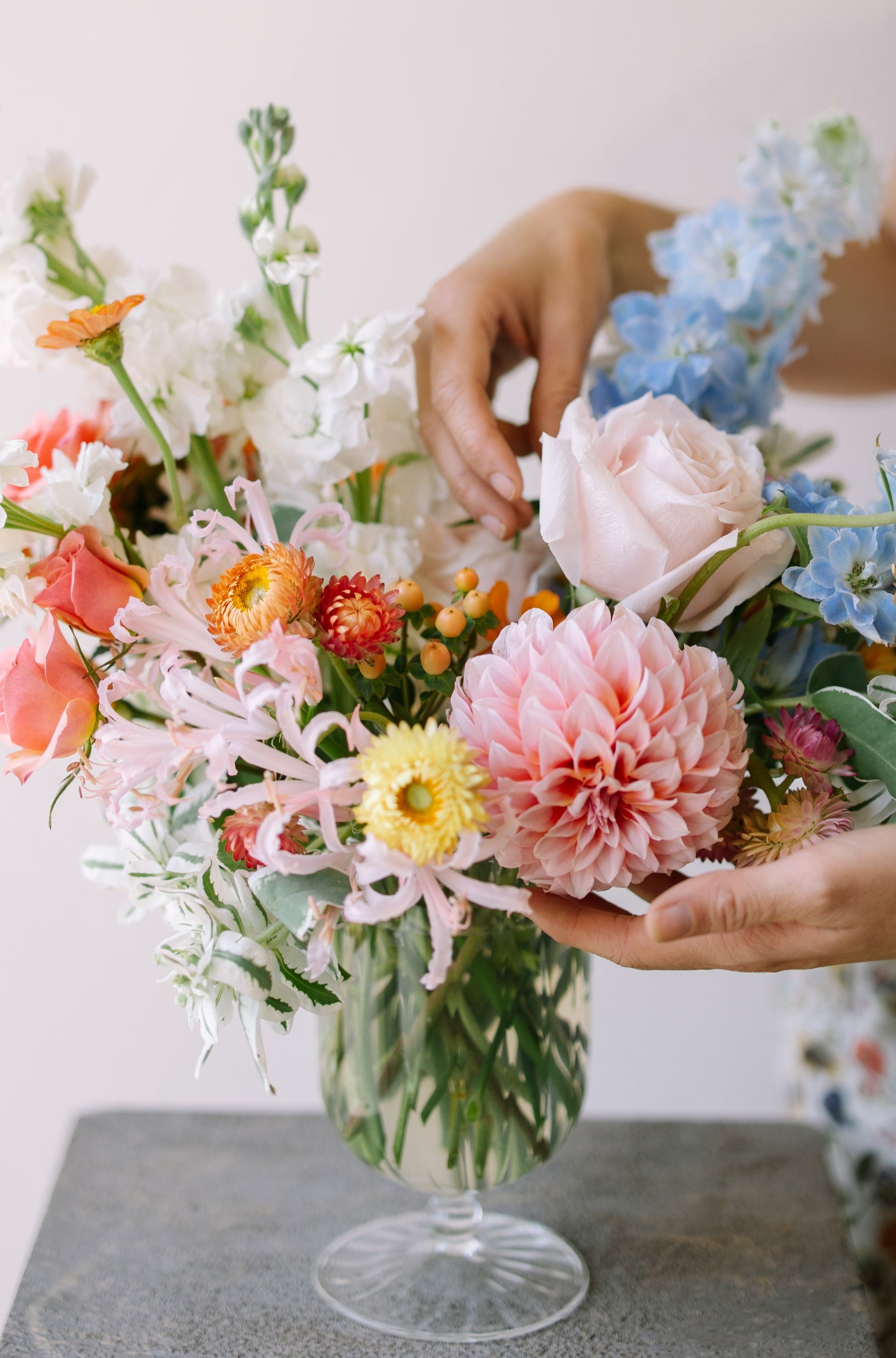 Garden flower arrangement in a footed glass vase.