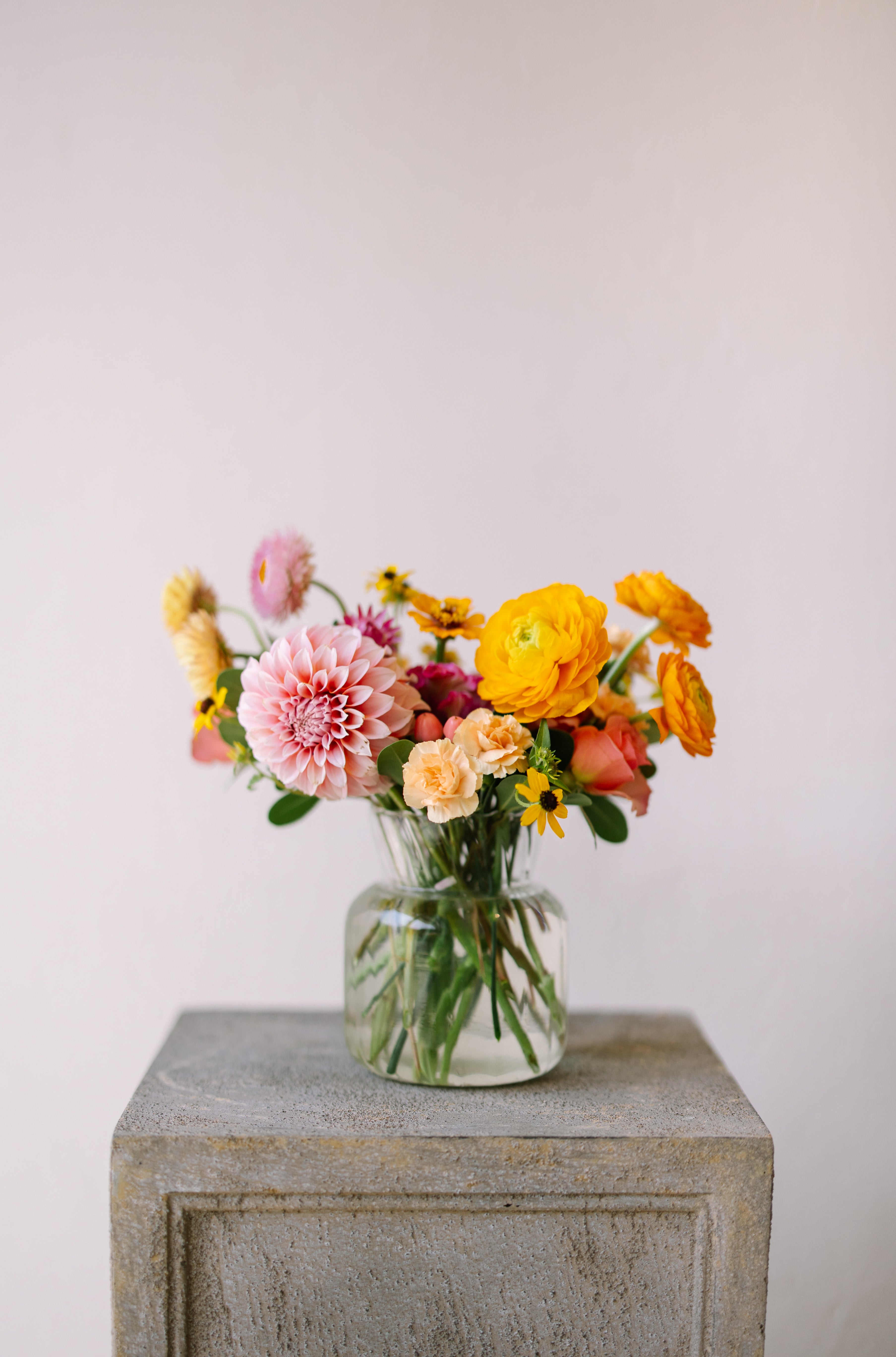 Cute and classic flower arrangement in ribbed glass vase.