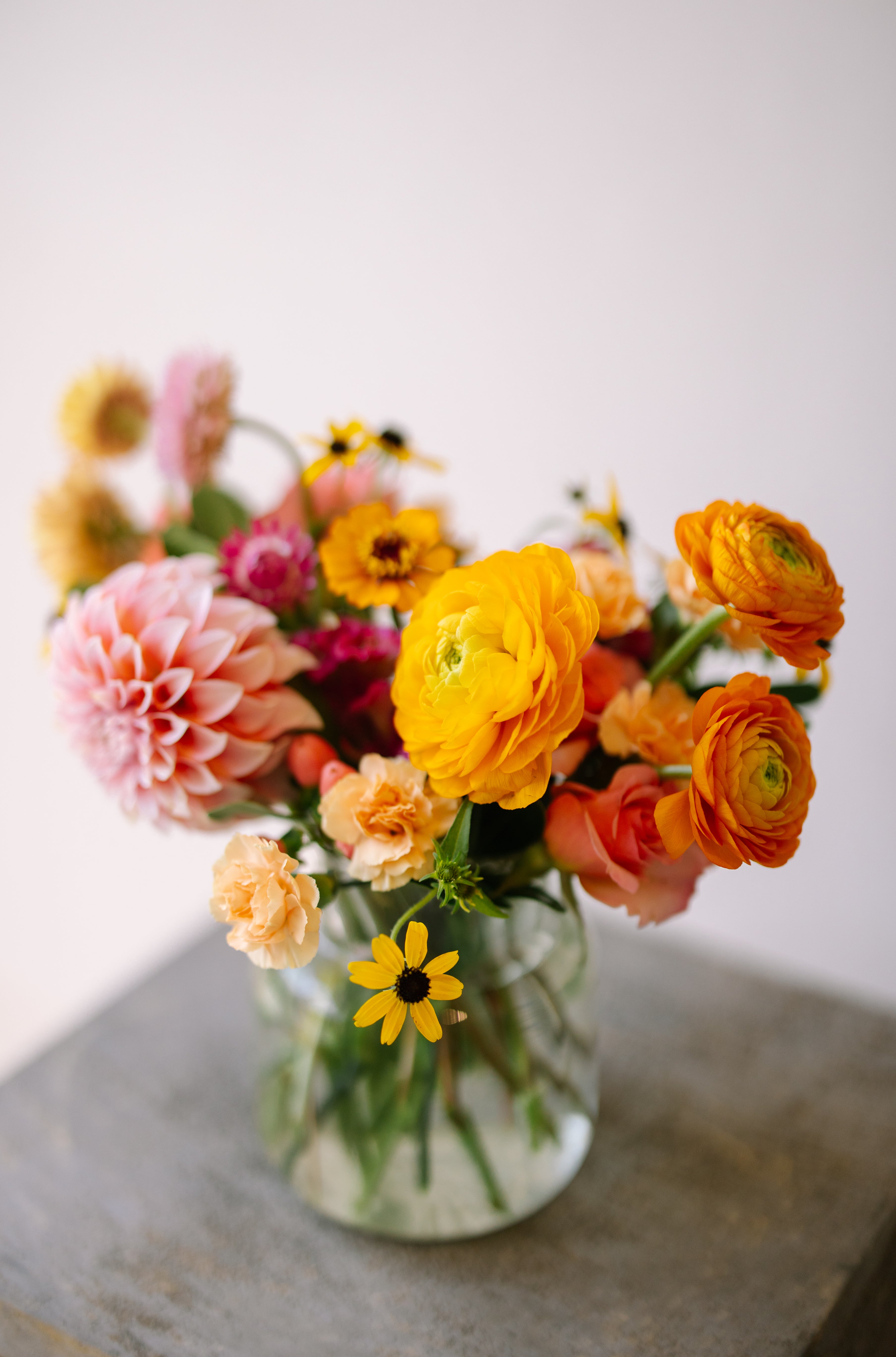 Cute and classic flower arrangement in ribbed glass vase.