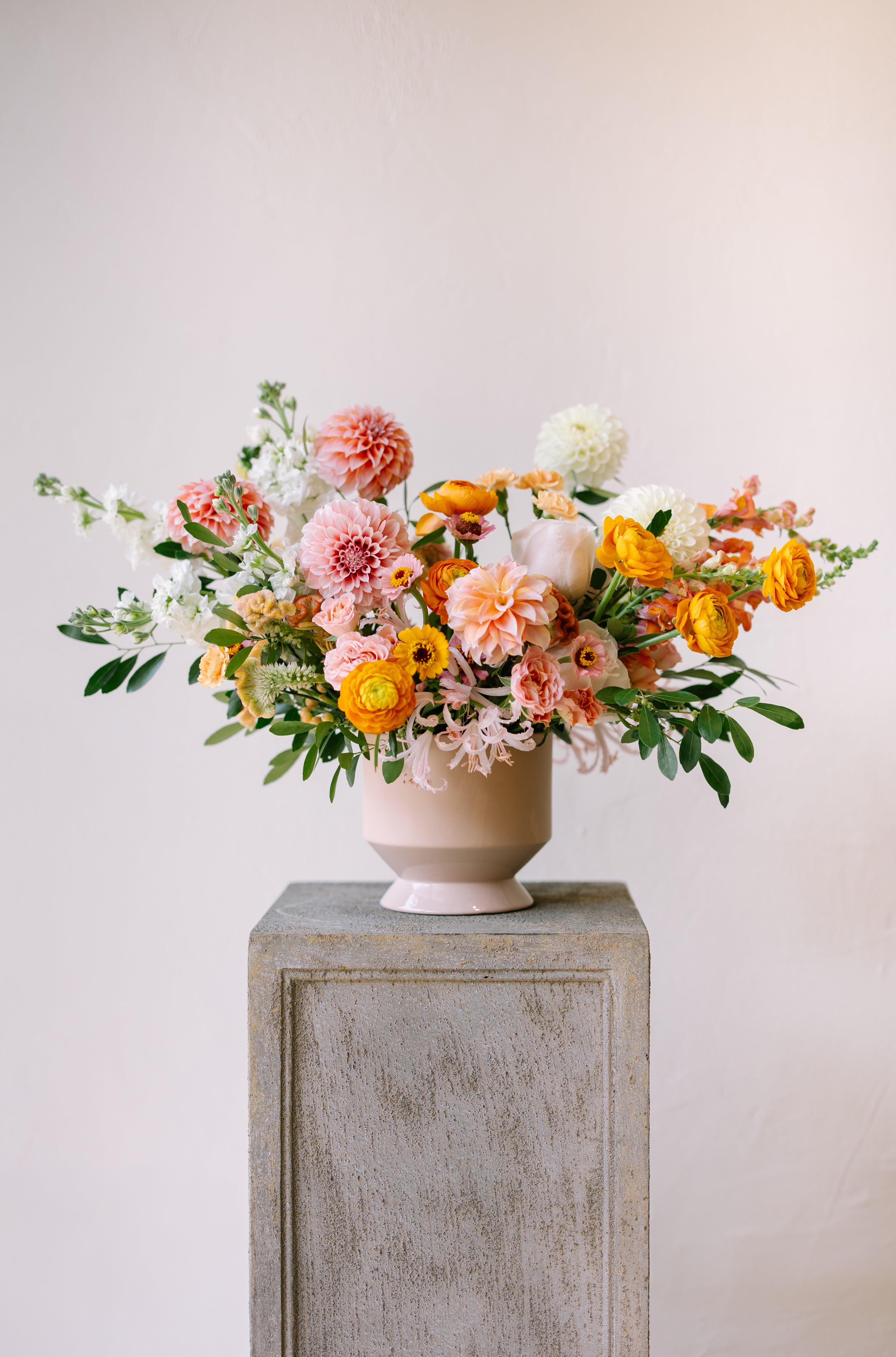 Luxury garden flower arrangement in neutral pink vase.