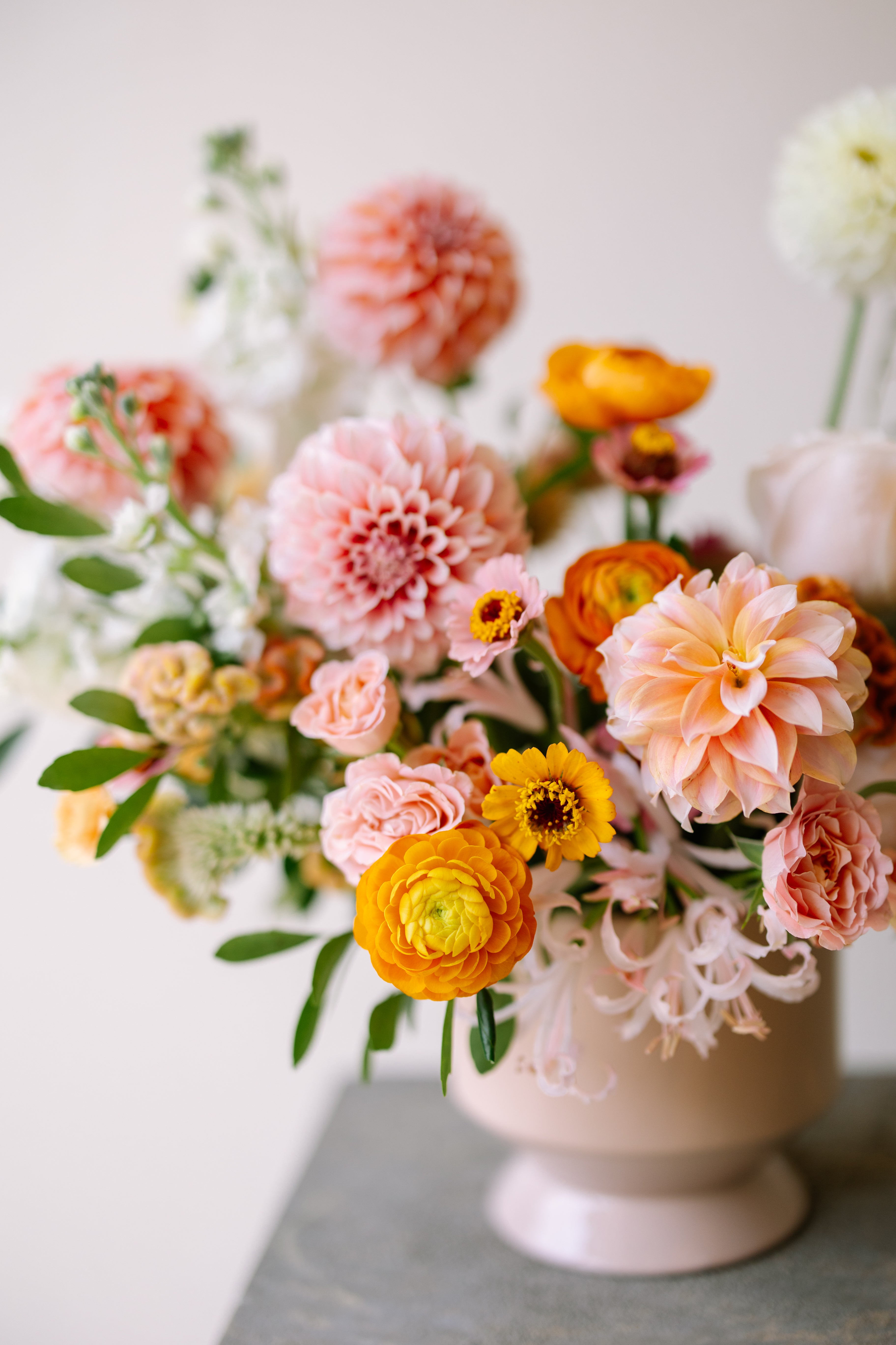 Luxury garden flower arrangement in neutral pink vase.