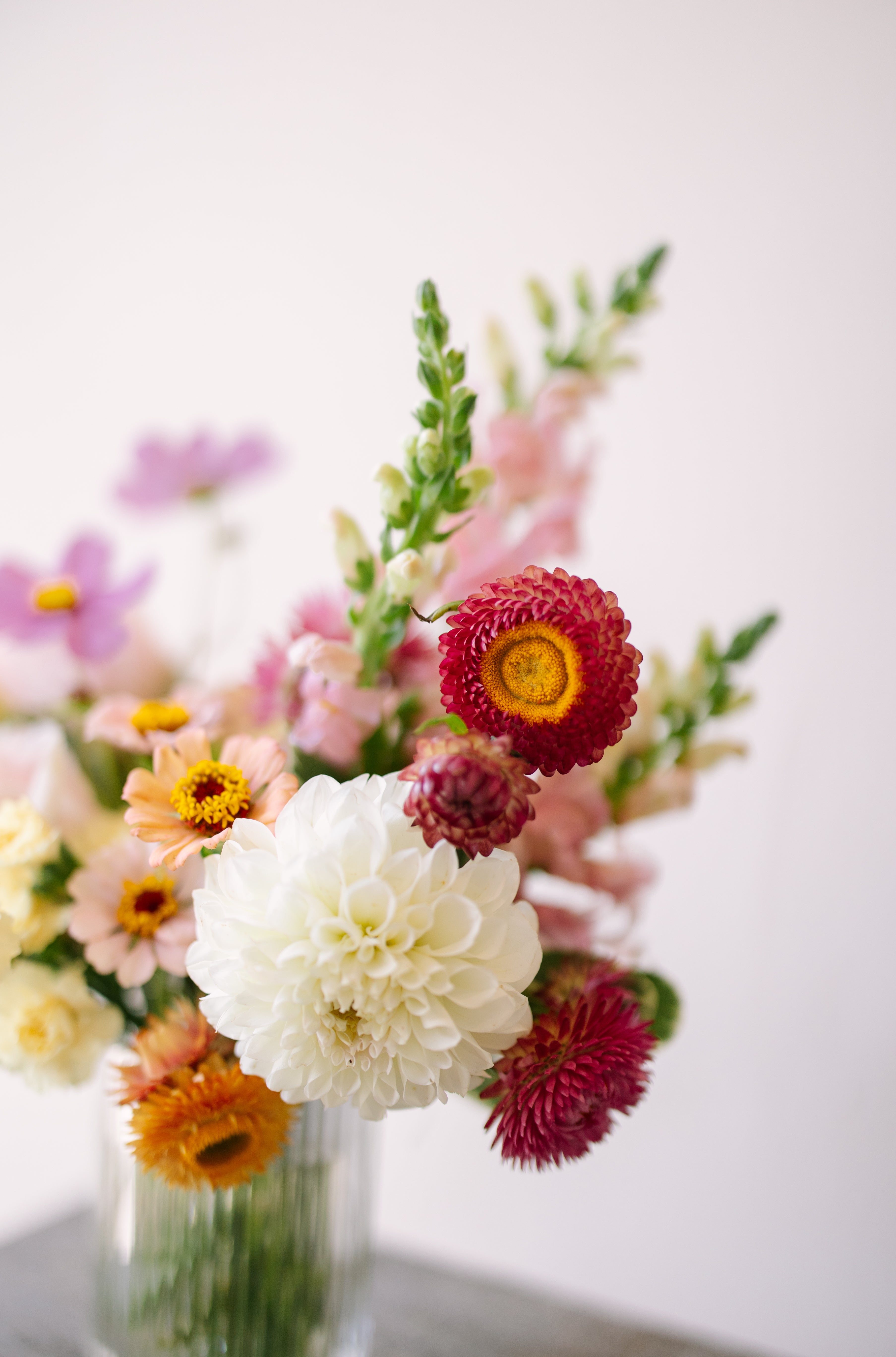 Small flower arrangement in ribbed glass vessel.