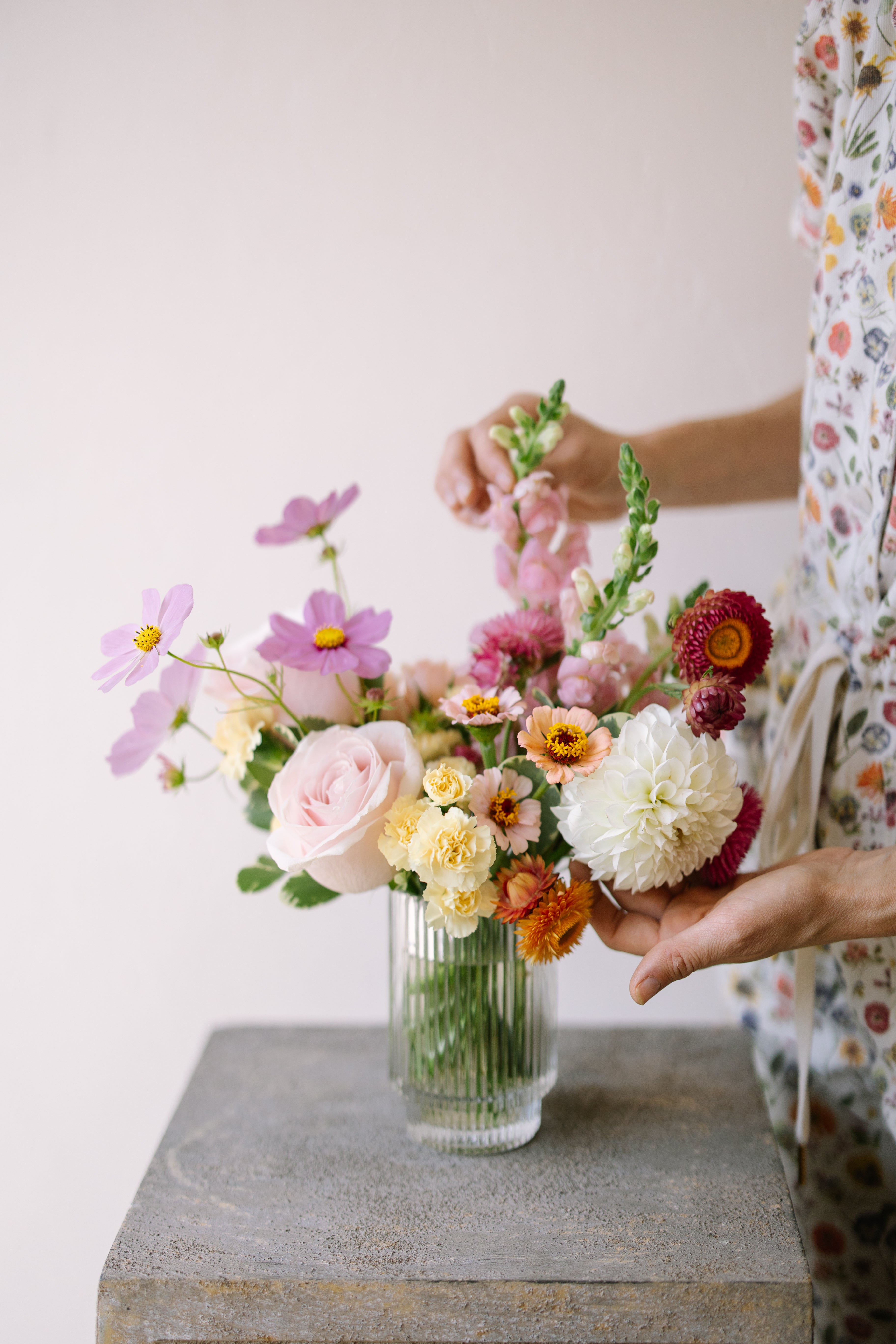 Small flower arrangement in ribbed glass vessel.