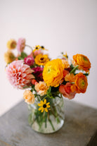 Cute and classic flower arrangement in ribbed glass vase.