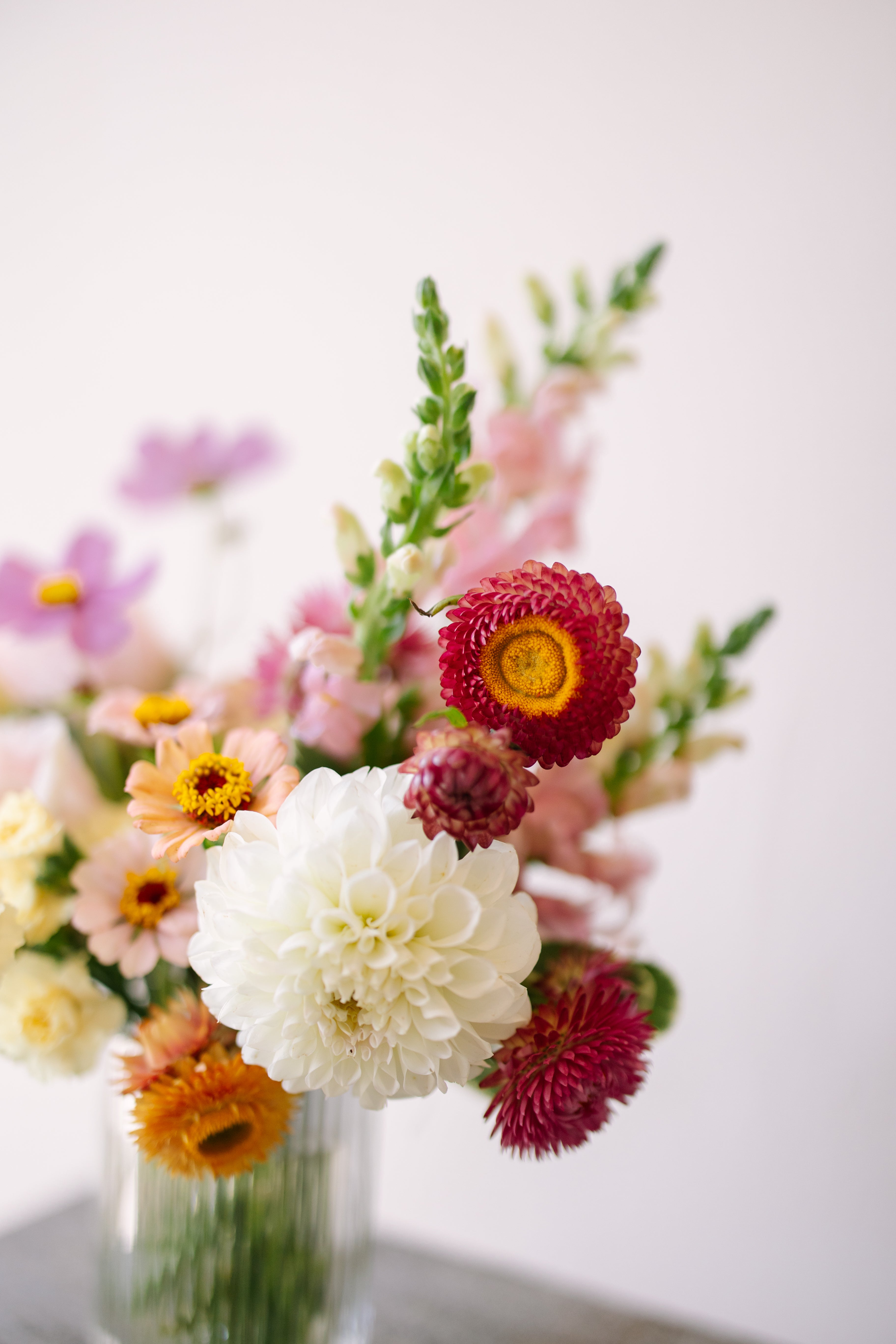 Small flower arrangement in ribbed glass vessel.